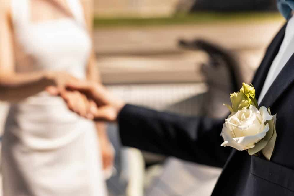 Side view bride and groom holding hands