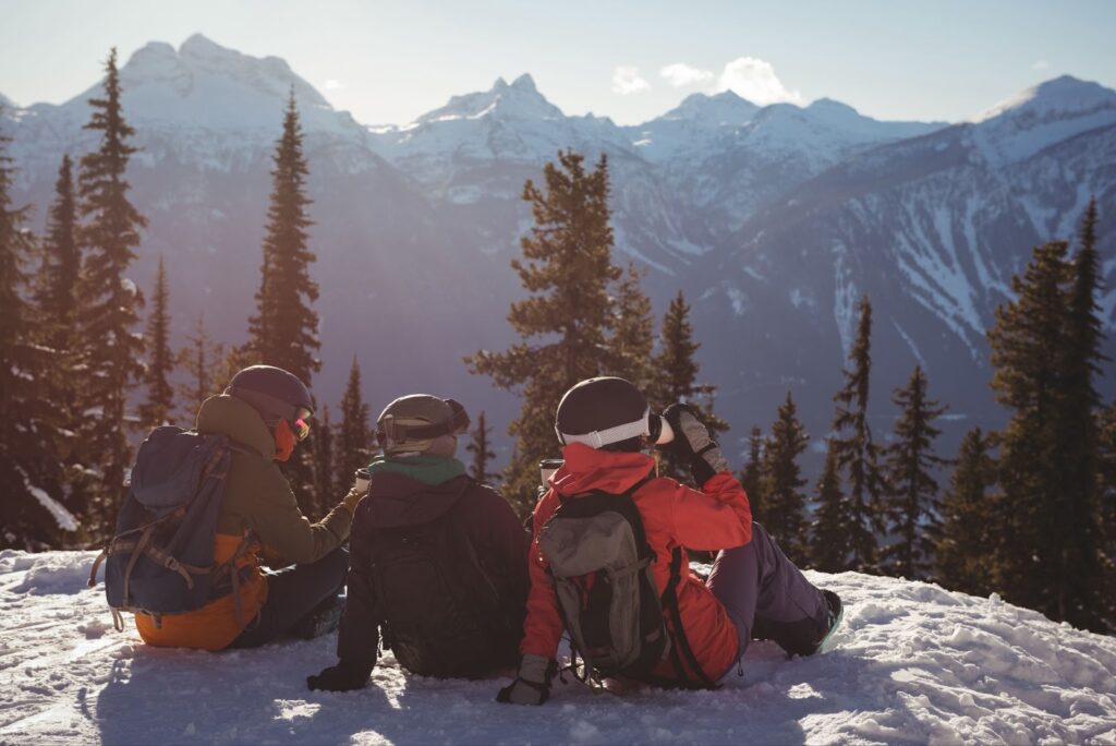 Three skiers relaxing on snow covered mountain