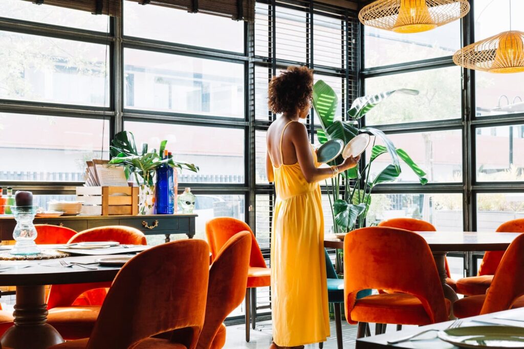 Side view of young woman looking at two different plates in the restaurant